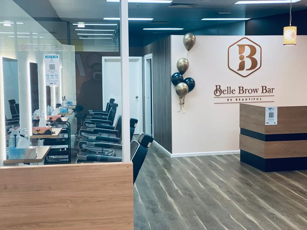 Belle Brow Bar reception — logo on the wall, styling stations, glass frontage