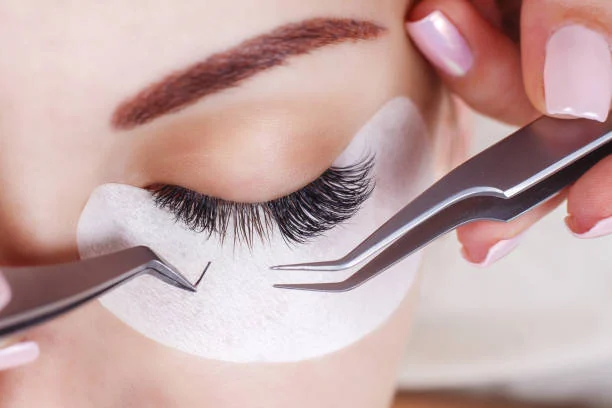 Individual lash extension placed with tweezers — close focus