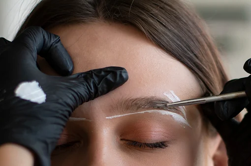 Brow tint being applied with white paste